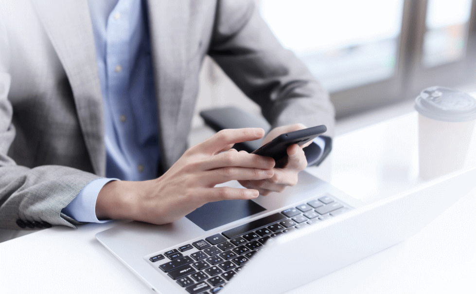 ノートパソコンとスマートフォンを持ったサラリーマン
